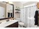 Well-lit bathroom featuring a dark vanity, a modern shower curtain and black shelving at 4048 Sandy Branch Ne Dr, Buford, GA 30519