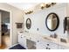 Spacious bathroom featuring double sinks, white cabinetry, and decorative oval mirrors for a luxurious feel at 4048 Sandy Branch Ne Dr, Buford, GA 30519