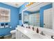 Vibrant blue bathroom featuring double sinks, a large mirror, and a shower with a patterned curtain at 4048 Sandy Branch Ne Dr, Buford, GA 30519