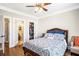 Comfortable bedroom with hardwood floors, a patterned bedspread, and access to an ensuite bathroom and closet at 4048 Sandy Branch Ne Dr, Buford, GA 30519