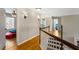 Upstairs hallway with hardwood floors, leading to various rooms, including a bedroom and bathroom at 4048 Sandy Branch Ne Dr, Buford, GA 30519