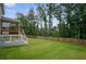 Spacious backyard with lush lawn, bordered by a wooden fence, and featuring a raised deck with staircase at 66 Snowdon Way, Villa Rica, GA 30180