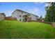 Spacious backyard featuring lush green grass, wood fence, and stairs leading to the back of the home at 66 Snowdon Way, Villa Rica, GA 30180