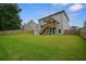 Home's exterior showcases a spacious, fenced backyard with a lush lawn and an elevated wooden deck at 66 Snowdon Way, Villa Rica, GA 30180