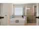 Bathroom with bathtub and glass-enclosed shower with light tile at 66 Snowdon Way, Villa Rica, GA 30180