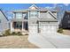 Charming two-story home with grey siding, stone accents, a covered porch, and a two-car garage at 66 Snowdon Way, Villa Rica, GA 30180