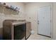 Functional laundry room with modern washer and dryer and shelving at 66 Snowdon Way, Villa Rica, GA 30180