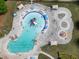 Aerial view of community pool with lounge chairs, umbrellas, water playground, and splash area at 66 Snowdon Way, Villa Rica, GA 30180