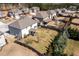 Aerial view of a spacious backyard with a privacy fence, mature trees, and a covered patio at 2401 Day Break Way, Dacula, GA 30019