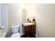 Bathroom featuring dark wooden cabinets, granite countertop, white basin, and toilet at 2401 Day Break Way, Dacula, GA 30019