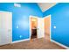 A blue bedroom with neutral carpet features bright white doors, trim, and vaulted ceiling at 2401 Day Break Way, Dacula, GA 30019