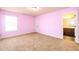 Bright pink bedroom with neutral carpet with bright white trim and doorway to a bathroom at 2401 Day Break Way, Dacula, GA 30019