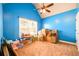 Bright blue bedroom featuring a ceiling fan, and a large window at 2401 Day Break Way, Dacula, GA 30019