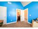 A blue bedroom with neutral carpet features bright white doors, trim, and vaulted ceiling at 2401 Day Break Way, Dacula, GA 30019