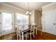 Bright dining area featuring wood floors, a modern chandelier, and a window overlooking the backyard at 2401 Day Break Way, Dacula, GA 30019