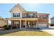 Charming two-story brick home with a welcoming front porch and well-manicured lawn at 2401 Day Break Way, Dacula, GA 30019