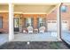 Inviting front porch featuring rocking chairs, stone accents, and a decorative front door at 2401 Day Break Way, Dacula, GA 30019