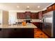 Spacious kitchen featuring stainless steel appliances, dark cabinets, a granite counter, and hardwood flooring at 2401 Day Break Way, Dacula, GA 30019