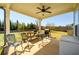 Outdoor patio with ceiling fan, grill, seating and view of the spacious backyard at 2401 Day Break Way, Dacula, GA 30019