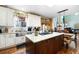 Well-lit kitchen with stainless steel appliances, granite counters, island, and classic white cabinetry at 5034 Kingsbridge Pass, Powder Springs, GA 30127