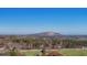 Scenic aerial view of lush landscape with a mountain in the distance against a clear blue sky at 5690 Rutland Trce, Lithonia, GA 30058