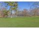 Expansive backyard featuring a tranquil pond surrounded by mature trees and lush green lawn at 5690 Rutland Trce, Lithonia, GA 30058