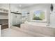 Bathroom features a luxurious soaking tub and a glass-enclosed shower, perfect for relaxation and rejuvenation at 5690 Rutland Trce, Lithonia, GA 30058