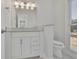 Cozy white bathroom featuring modern vanity, sink, and toilet at 5690 Rutland Trce, Lithonia, GA 30058