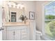 Well-lit bathroom featuring white cabinetry, granite countertops, and natural light from the window at 5690 Rutland Trce, Lithonia, GA 30058