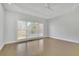 Bright bedroom with a large window offering natural light and scenic outdoor views and hardwood floors at 5690 Rutland Trce, Lithonia, GA 30058