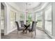 Cozy breakfast nook featuring modern gray chairs, glass top table, and serene view through large windows at 5690 Rutland Trce, Lithonia, GA 30058