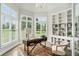Elegant home office with built-in shelving, a desk, and a beautiful view of the lawn at 5690 Rutland Trce, Lithonia, GA 30058