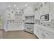 Bright kitchen boasts white cabinets, stainless steel appliances, and modern backsplash at 5690 Rutland Trce, Lithonia, GA 30058