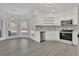 Open kitchen with white cabinets, stainless steel appliances, and lots of natural light at 5690 Rutland Trce, Lithonia, GA 30058