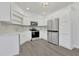 Bright kitchen featuring stainless steel appliances, white cabinetry, and gray backsplash at 5690 Rutland Trce, Lithonia, GA 30058