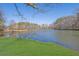 Scenic view of the private pond surrounded by mature trees and verdant green lawn at 5690 Rutland Trce, Lithonia, GA 30058