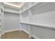 Organized walk-in closet offering ample storage space with multiple shelves and rods for clothing and accessories at 5690 Rutland Trce, Lithonia, GA 30058