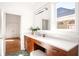 Bathroom featuring a vanity with wooden cabinets, a large mirror, and a window with natural light, creating a serene space at 629 Hansell Se St, Atlanta, GA 30312