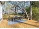 Wooden deck featuring an outdoor dining table, set among mature trees, perfect for entertaining at 629 Hansell Se St, Atlanta, GA 30312