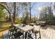 Wooden deck features a dining table and a seating area, surrounded by mature trees and greenery at 629 Hansell Se St, Atlanta, GA 30312