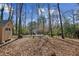 Backyard featuring lots of large trees and a storage shed at 703 Somerset Dr, Lawrenceville, GA 30046