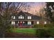 Charming two-story home at dusk, featuring a welcoming front porch, well-maintained lawn, and a red front door at 703 Somerset Dr, Lawrenceville, GA 30046