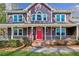 Charming two-story home with a welcoming front porch, well-maintained lawn and a red front door at 703 Somerset Dr, Lawrenceville, GA 30046