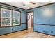 Spacious living room with wood-look floors, large window and blue accent wall paint at 703 Somerset Dr, Lawrenceville, GA 30046