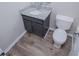 This bathroom features a gray vanity with a granite top, toilet, and luxury vinyl plank flooring at 195 W Fork Way, Temple, GA 30179