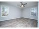 This bedroom features a ceiling fan, two windows, and luxury vinyl plank flooring at 195 W Fork Way, Temple, GA 30179