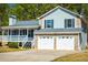 View of the home's exterior showcasing the covered porch, stone accents, and a two-car garage at 195 W Fork Way, Temple, GA 30179