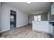 Open layout featuring kitchen with white cabinets and stainless steel appliances, with view to a separate living area at 195 W Fork Way, Temple, GA 30179