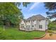 Home exterior showing a verdant lawn with a deck and a house with white siding at 4780 Woodruff Trce, Cumming, GA 30028