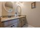 Bathroom vanity featuring double sinks, granite countertops, and framed oval mirrors at 4780 Woodruff Trce, Cumming, GA 30028